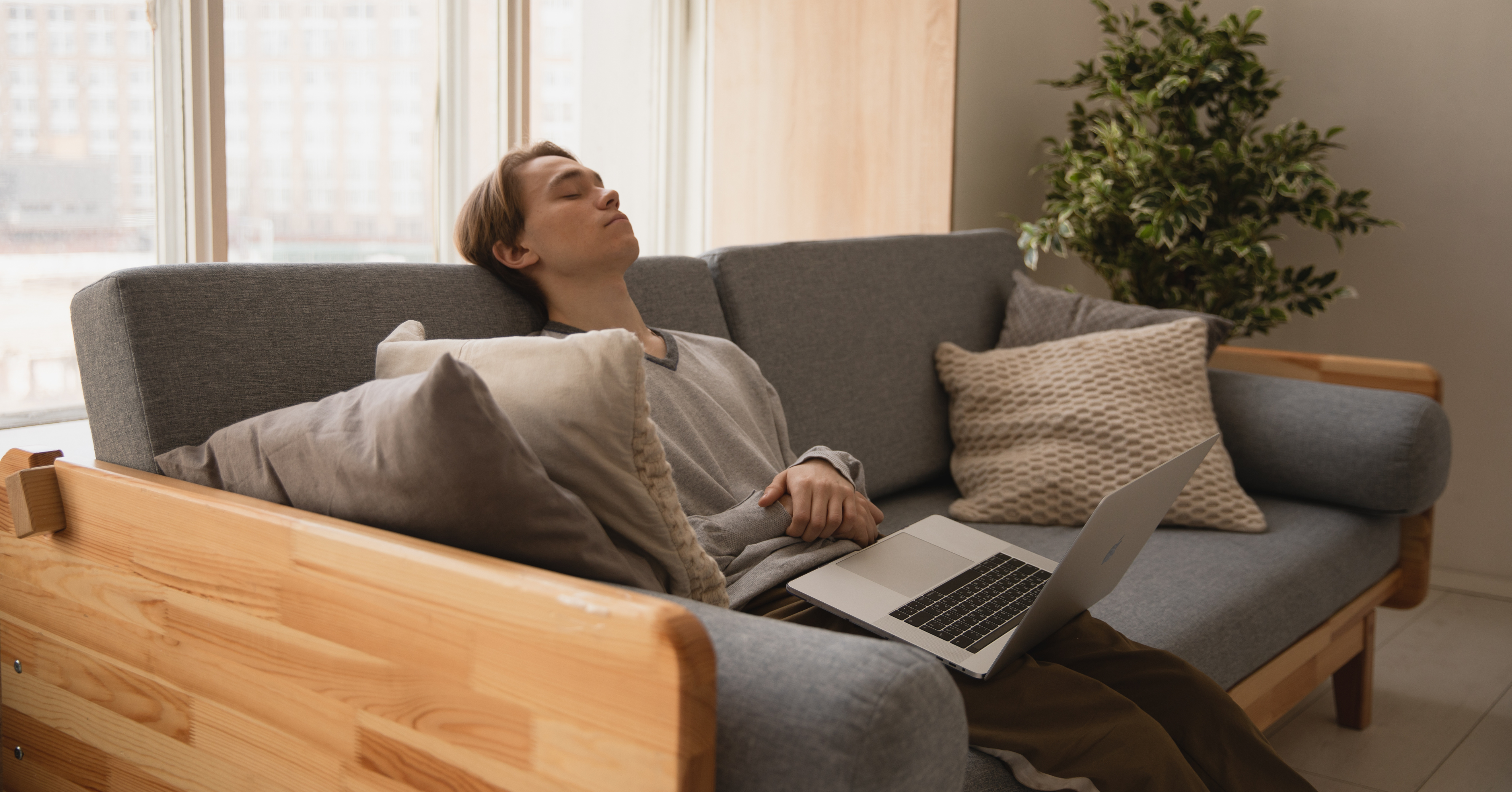Man tired on sofa with laptop